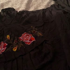 Black off shoulder shirt with flower on the sleeve